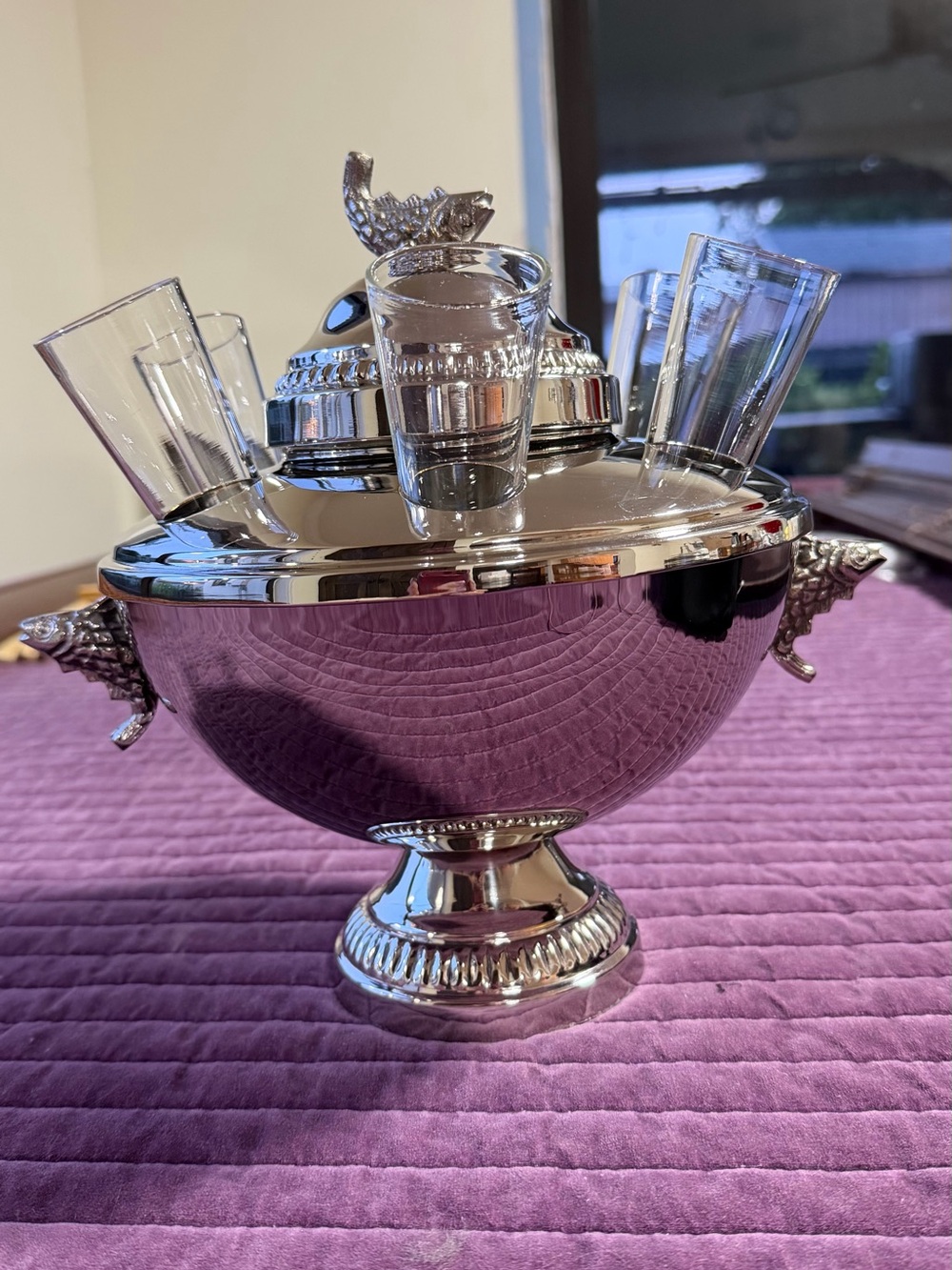 Silver-colored caviar bowl with vodka glasses - an elegant table centerpiece.
